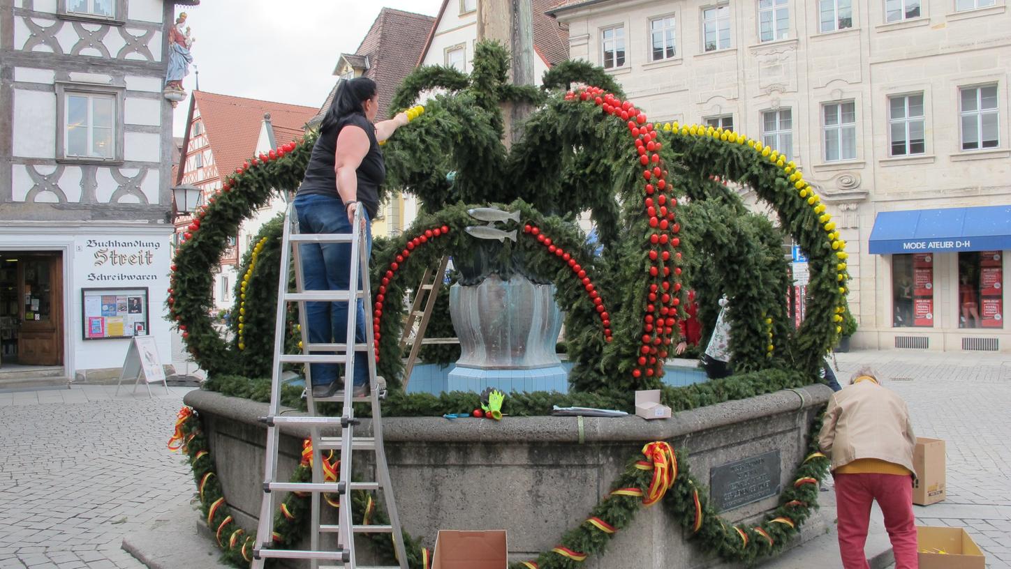 Die Eier sind da, der Hase kann kommen: Der Kriegbrunnen am Rathaus wird österlich geschmückt. In diesem Jahr sogar in den Stadtfarben Forchheims.
