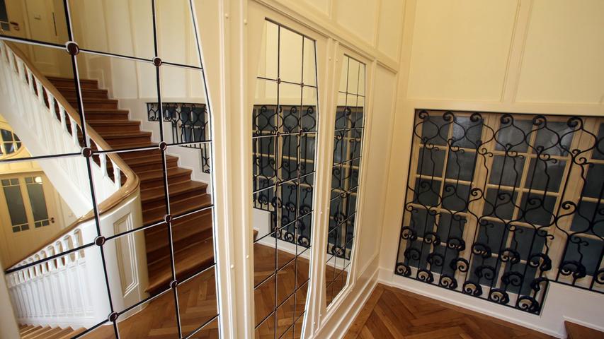 Blick ins Treppenhaus mit innenliegenden Fenstern und Spiegel.