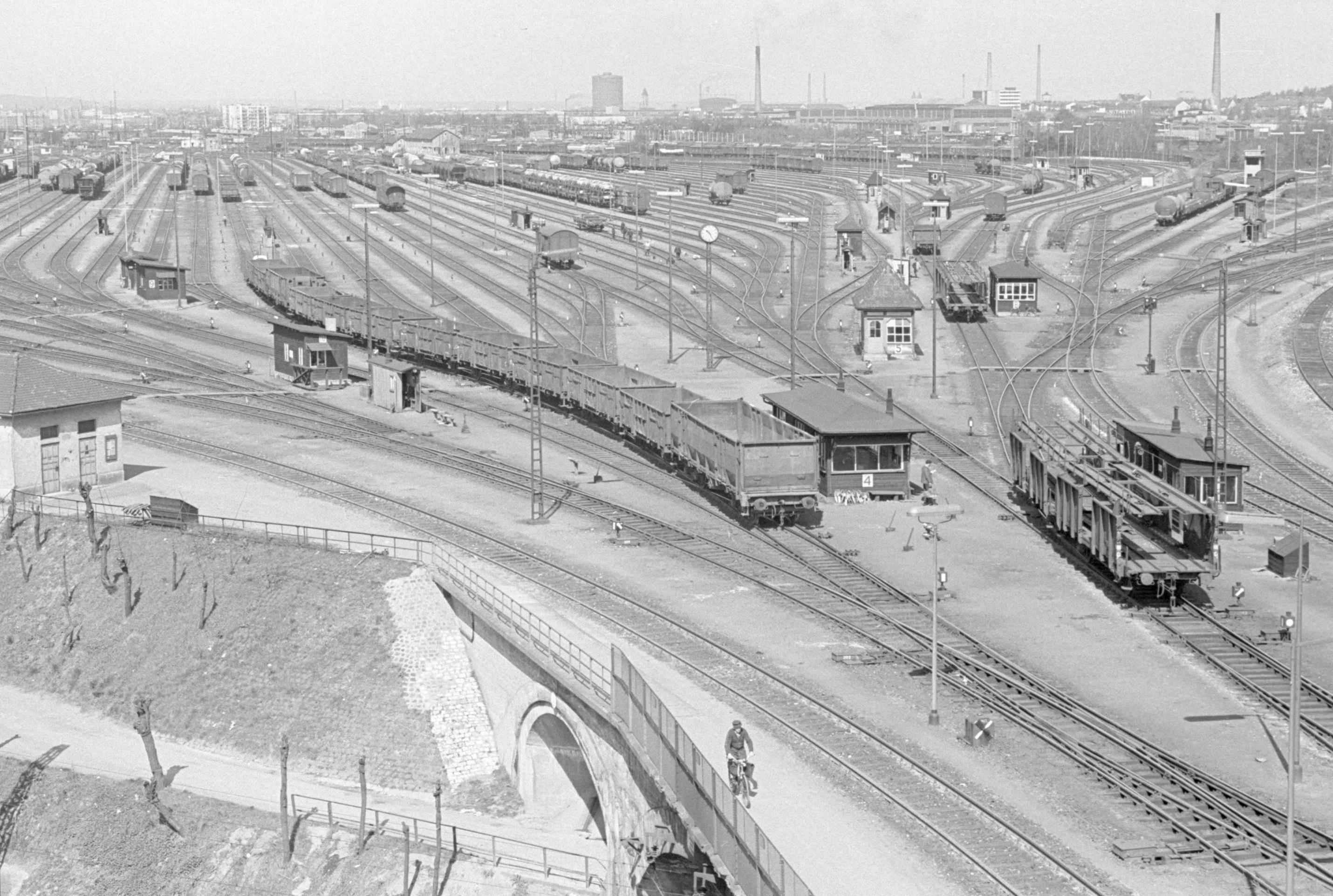 Ein Blick auf das scheinbar wirre Durcheinander von Schienen, Oberleitungs- und Beleuchtungsmasten auf dem Nürnberger Rangierbahnhof. Dazwischen liegen verstreut sechzehn "Mini"-Stellwerke, die nach der Umstellung auf die Elektronik verschwunden sein werden. Hier geht es zum Artikel vom 28. April 1967: Elektronik steuert Güterwagen.
Ein Blick auf das scheinbar wirre Durcheinander von Schienen, Oberleitungs- und Beleuchtungsmasten auf dem Nürnberger Rangierbahnhof. Dazwischen liegen verstreut sechzehn "Mini"-Stellwerke, die nach der Umstellung auf die Elektronik verschwunden sein werden. Hier geht es zum Artikel vom 28. April 1967: Elektronik steuert Güterwagen.