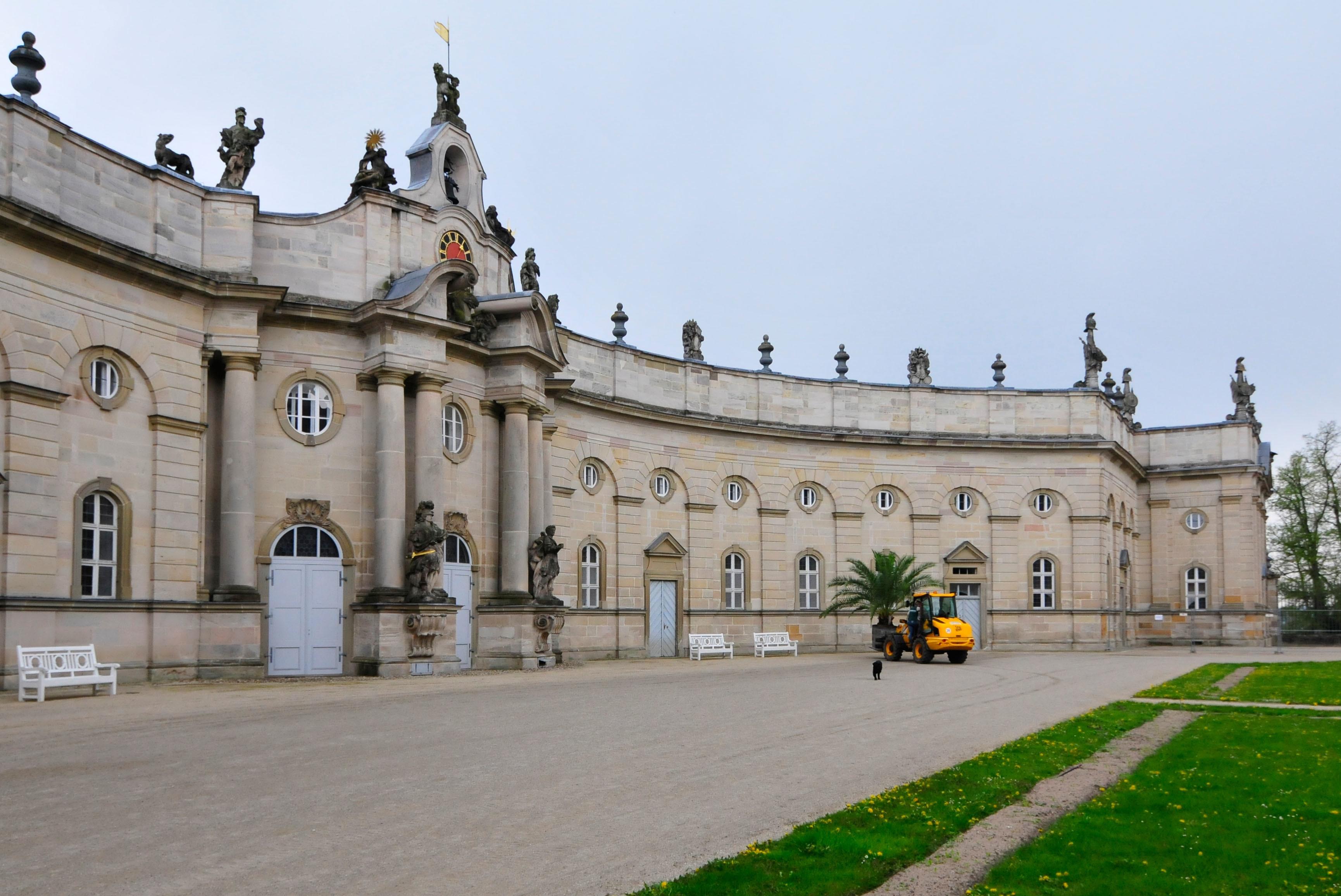 Die Palmen auf Schloss Weißenstein in Pommersfelden ziehen von ihrem Winterquartier, dem Palmenhaus, in den Ehrenhof um. Mit dem Radlader sind Anja und Michael Schlapp zugange.