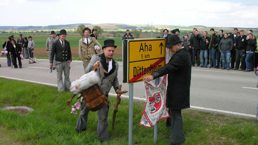 Übers Schild drüber oder unten durch: Wie alle der Walz heimkehrenden Gesellen musste auch Manuel Mährlein (links) dem Brauch entsprechend das Ortsschild überwinden.