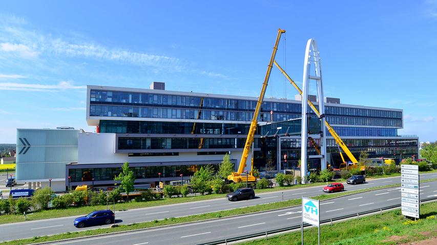 Schon fast in ganzer Pracht: Brückenteil 2 sitzt zwischen Bestandsgebäude und dem Pylon. Am Wochenende, 19. bis 21. Mai, wird der Brückenschlag vollendet.