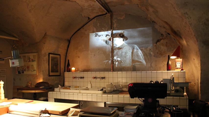 Im Eingangsbereich, der wie die Küche eines Serienmörders anmutet, laufen alte Horrorfilme in schwarz-weiß.