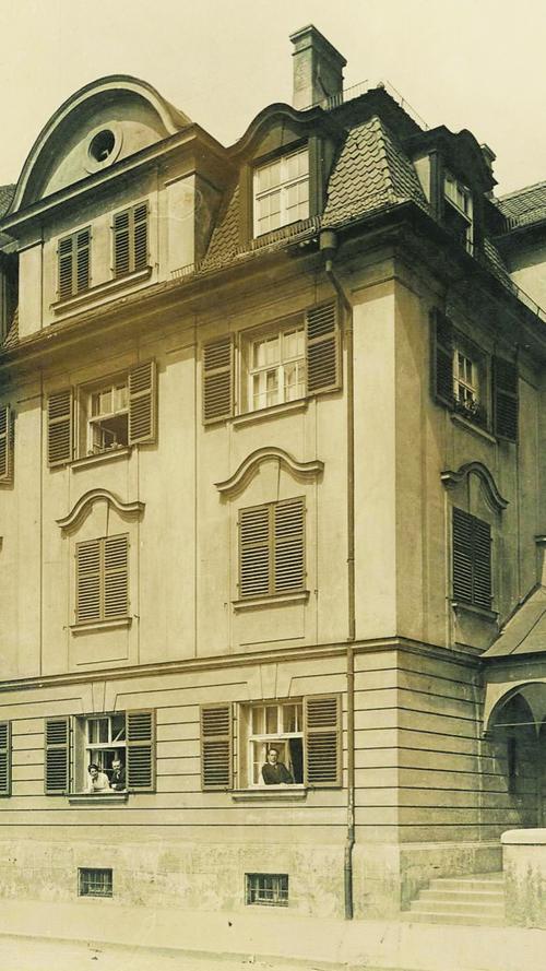 Pfarrer Kinle (im Erdgeschoss re.), seine Mitbewohner und Gemeindemitarbeiter posieren 1922 an den Fenstern des Pfarrhauses für den Fotografen.