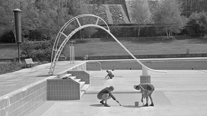 Mit grüner Spezialfarbe werden die Becken im Naturgartenbad gestrichen. Schon am Samstag geht es die Rutschbahn hinab in die so lange entbehrten kühlen Fluten im Freien.  Hier geht es zum Artikel vom 11. Mai 1967: Mit Schwung hinein....