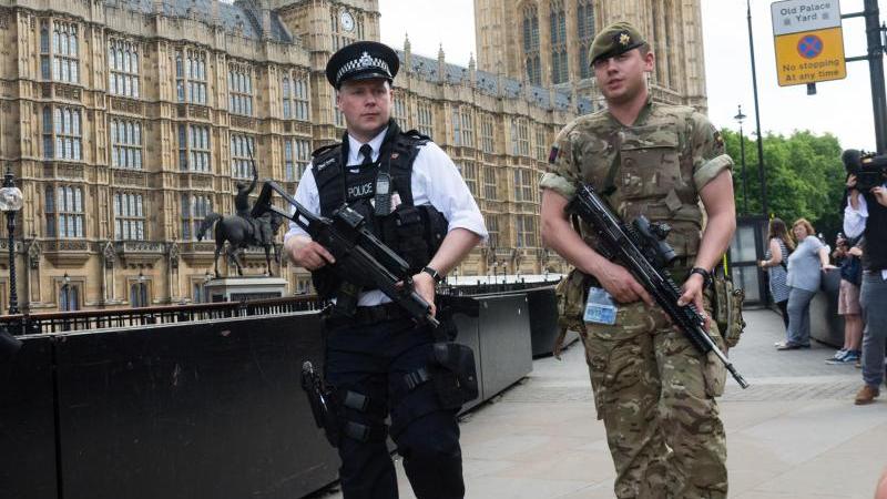Schwer bewaffnete Polizisten patrouillieren in London an Bord eines Zuges, der nach Birmingham unterwegs ist: Großbritannien ist weiterhin im Ausnahmezustand.