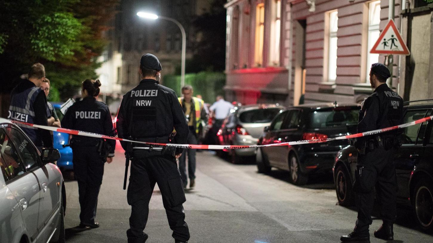 Polizisten sichern die Straße vor dem Wohnheim in Wuppertal-Elberfeld, nachdem in dem Gebäude drei Leichen gefunden wurden.