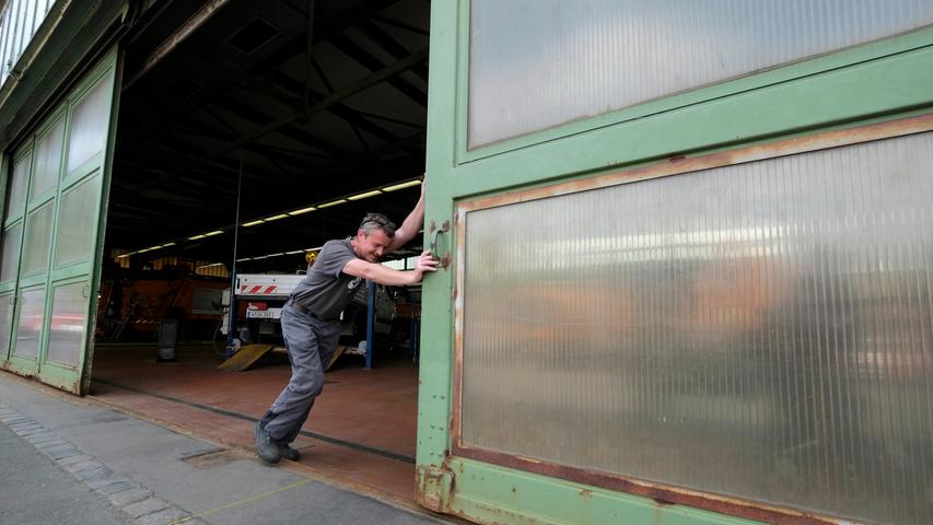 Kfz-Mechaniker Günter Amon muss vollen Körpereinsatz zeigen, um die Tore der Ex-Flugzeughalle aufschieben zu können.