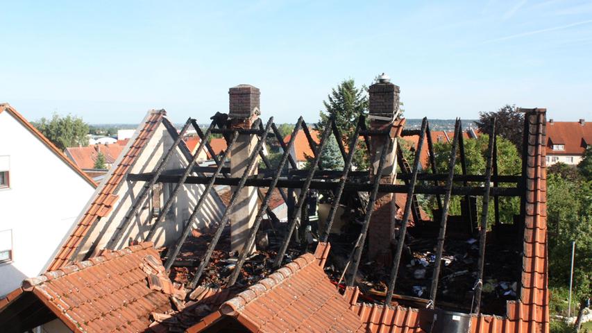 Nur noch verkohlte Balken sind von dem Dach eines Einfamilienhauses in Gunzenhausen nach dem Brand übrig.