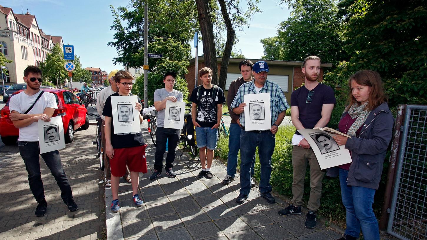 Die Initiative "Das Schweigen durchbrechen" hält Bilder der getöteten NSU-Opfer hoch. Die Gruppe erinnerte an der Nürnberger Scharrerstraße an den Mord vor zwölf Jahren.