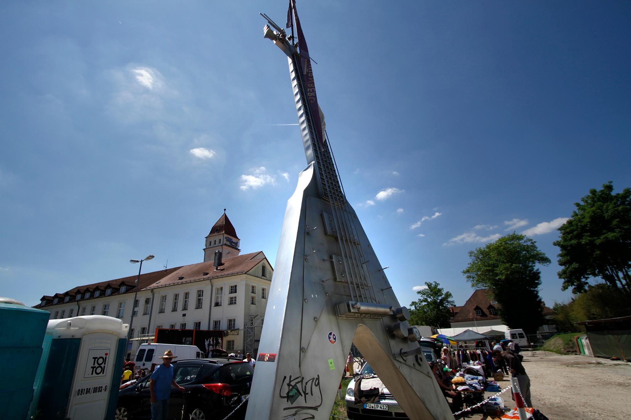 Eine sieben Meter hohe "Flying V"-Gitarre steht seit 2011 auf dem Resi-Parkplatz, aufgestellt von dem damaligen Betreiber der "Rockfabrik"-Disco. Samstag läuft hier ab und zu ein Flohmarkt.