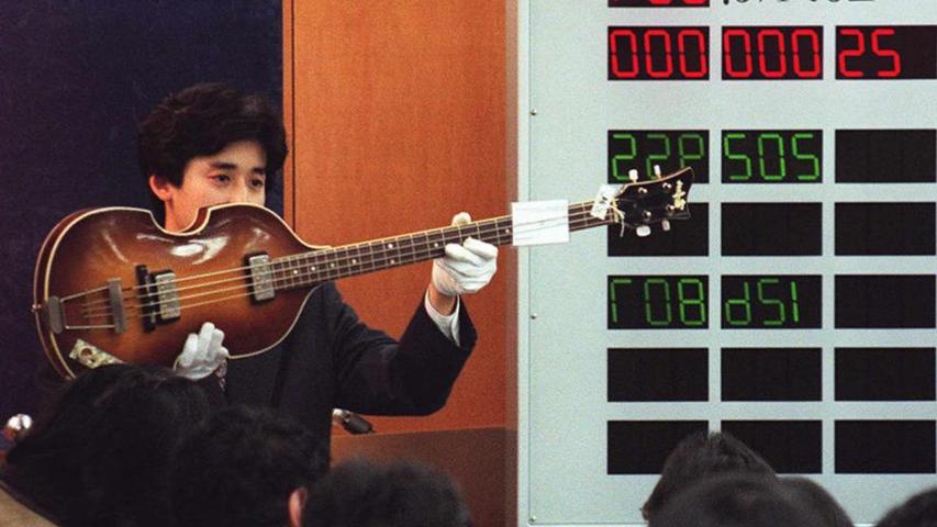 Ein Mitarbeiter eines Tokioer Auktionshauses präsentiert 1997 eine in Baiersdorf gefertigte Bass-Gitarre Höfner 500/1 aus dem Jahr 1964, die im Besitz von Paul McCartney war.
