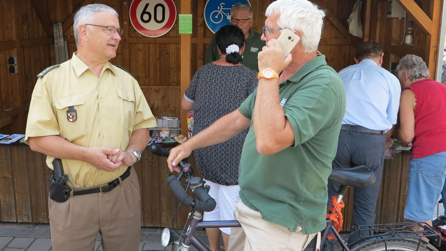 Polizeidienststellenleiter Harald Eckert und Roland Schmidt, Vorsitzender der Verkehrswacht Gunzenhausen, machen es vor: so nicht! Handys dürfen weder beim Radeln noch am Autosteuer genutzt werden.