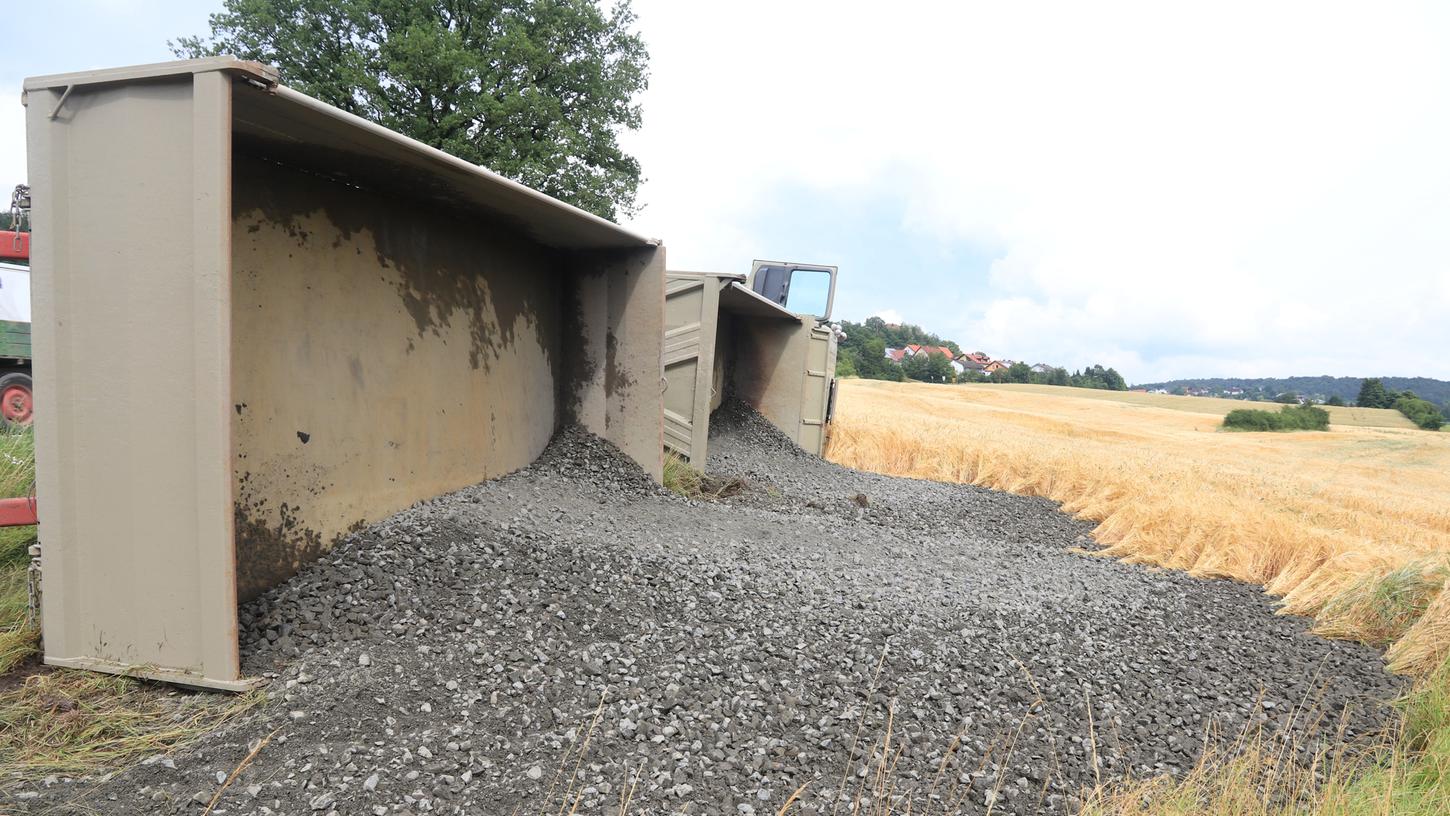 Teile der Schotterladung verteilten sich über die Wiese. Glücklicherweise wurde der Fahrer kaum verletzt. Teile der Schotterladung verteilten sich über die Wiese. Glücklicherweise wurde der Fahrer kaum verletzt.