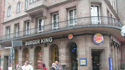 ... die Filialen schließen mussten. Wegen eines anderen Franchisers sind Burger King Filialen in der Nürnberger Region und Umland nicht betroffen (auf dem Bild die Nürnberger Filiale in der Königstraße im Herzen der Frankenmetropole). Drei Tage nach der fristlosen Kündigung, am 21.November 2014, beantragte Burger King eine einstweilige Verfügung gegen den umstrittenen Franchisenehmer Yi-Ko. Es ging dabei nicht um die umgehende Schließung, sondern um die Rechte Burger Kings an Schildern, Speisekarten, Arbeitskleidung sowie Logos.