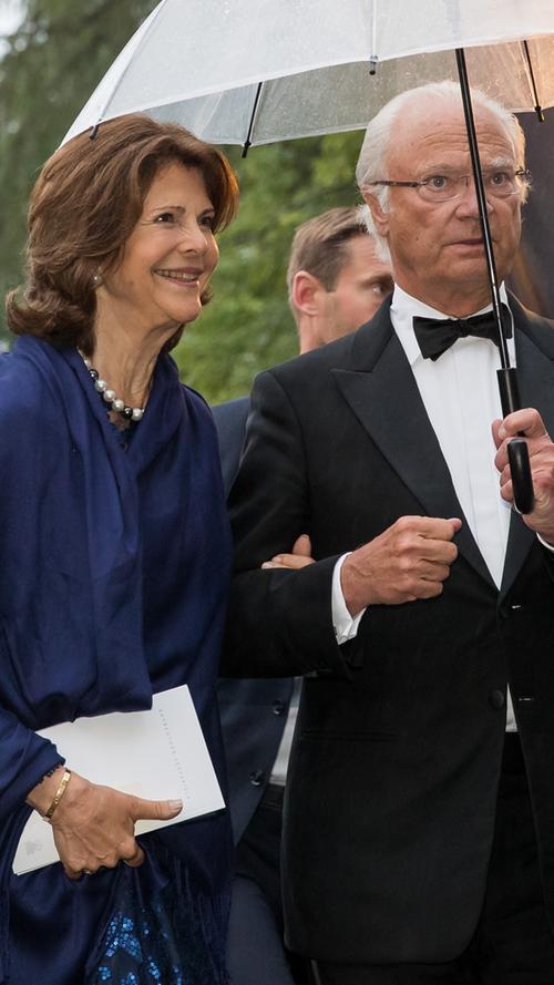 Königin Silvia und König Carl Gustaf von Schweden haben sich in einer Pause während der Eröffnung die Beine vertreten und gehen zurück zum Festspielhaus.