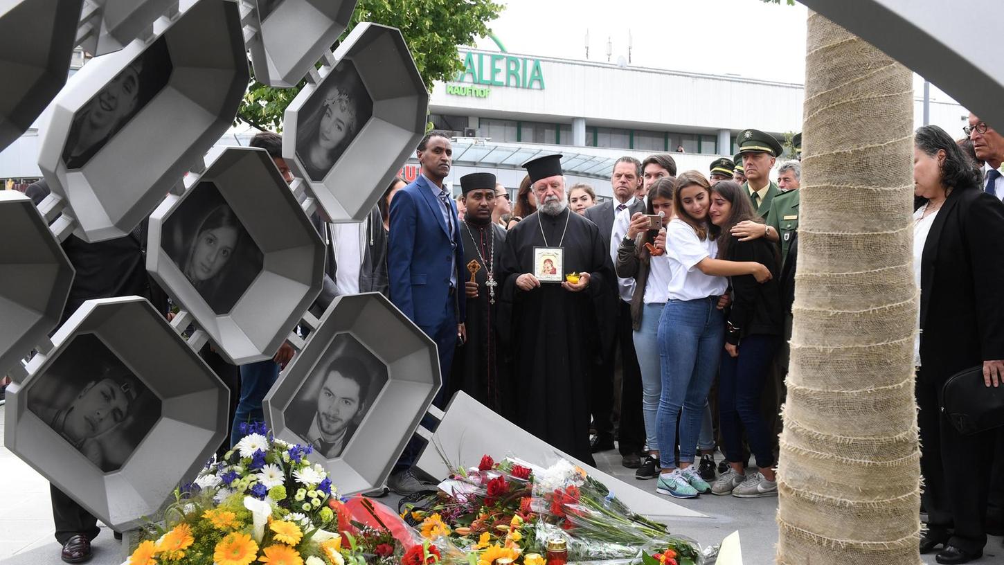 Am 22. Juli haben Angehörige zum Jahrestag des blutigen Ereignisses am Olympia-Einkaufszentrum in München der Opfer des Amoklaufs gedacht. Auf einem Denkmal sind Porträts der Getöteten abgebildet.