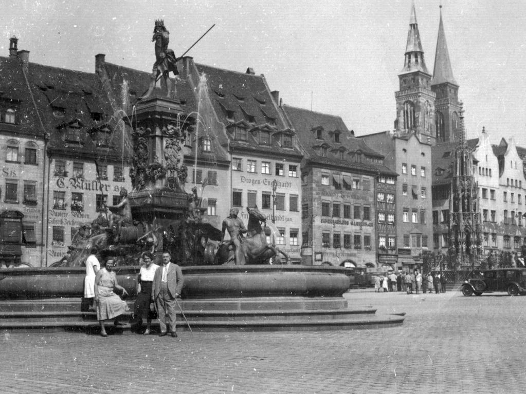 Der Neptunbrunnen 1931 vor städtischer Kulisse. Die Dame links im Bild ist Frieda Fünffinger, daneben stehen Bekannte. Für den Schönen Brunnen interessierte sich damals keiner.