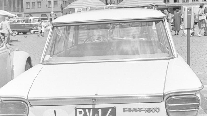 Rendevous am Hauptmarkt: Einträchtig stehen sie nebeneinander, der Wagen aus Italien (links) und der aus Großbritannien; ihre Insassen betrachten vermutlich das Männlein-Laufen. Doch die Zahl der ausländischen Gäste, die Nürnberg besuchen, ist im Jahr 1967 deutlich zurück gegangen.  Hier geht es zum Kalenderblatt vom 15. August 1967: Weniger Gäste als 1966