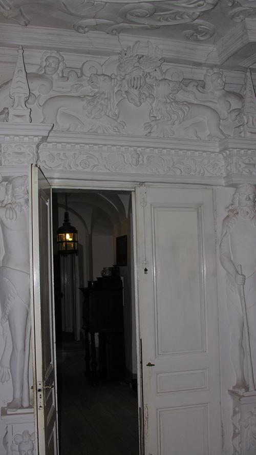 Der sogenannte weiße Saal wird von einer kunstvoll gefertigten Stuckdecke dominiert, die der Nürnberger Hans Kuhn zwischen 1616 und 1660 gestaltete. Auch die Tür ist reichhaltig verziert.