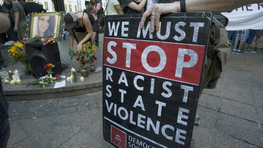 Das Konterfei der bei einer Nazi-Gegendemonstration in Charlottesville ums Leben gekommenen Frau und ein Plakat gegen rassisitische Gewalt ist in Atlanta bei einer Solidaritätsdemonstration aufgestellt.