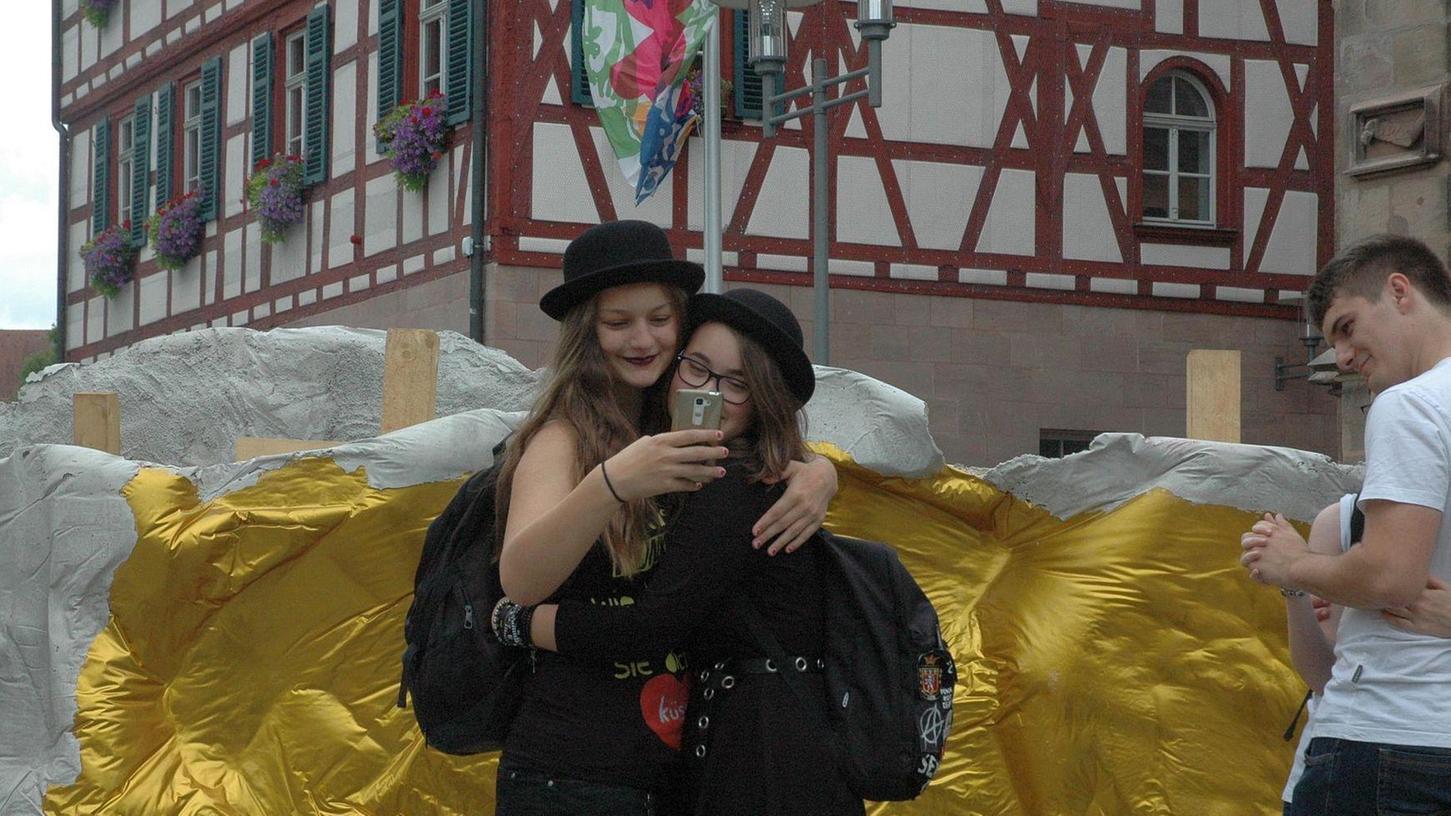 Zwei junge Besucherinnen haben ihren Foto-Spaß am Kunstwerk von Eyrich von Motz auf dem Martin-Luther-Platz.