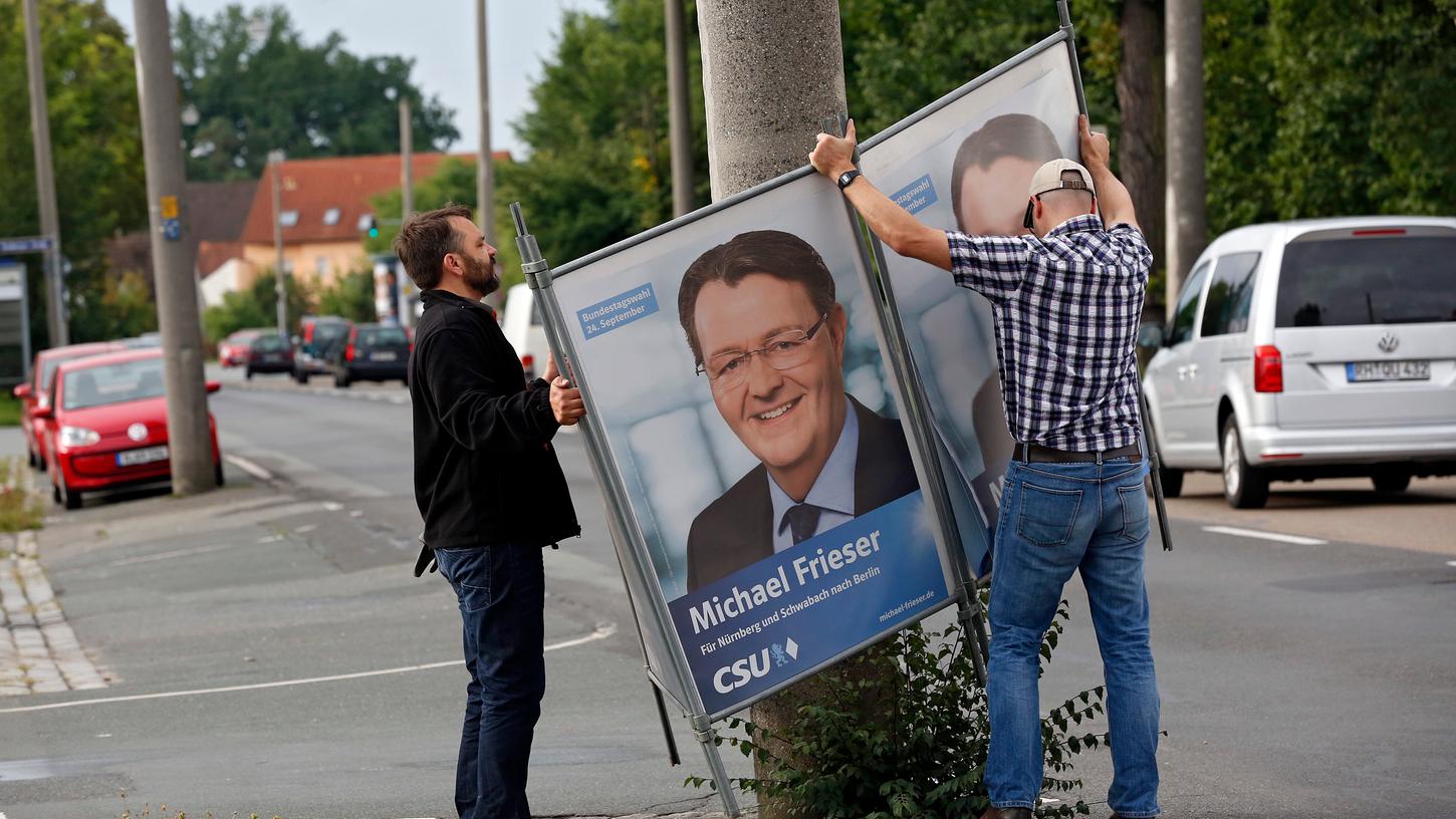 Passt so: CSU-Bundestagskandidat Michael Frieser wird von Parteihelfern um einen Pfeiler geklappt.