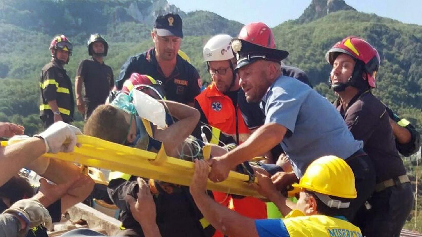 Feuerwehrleute und andere Rettungsrkräfte bergen am Dienstag auf der Insel Ischia den kleinen Mattias aus einem eingestürzten Haus.