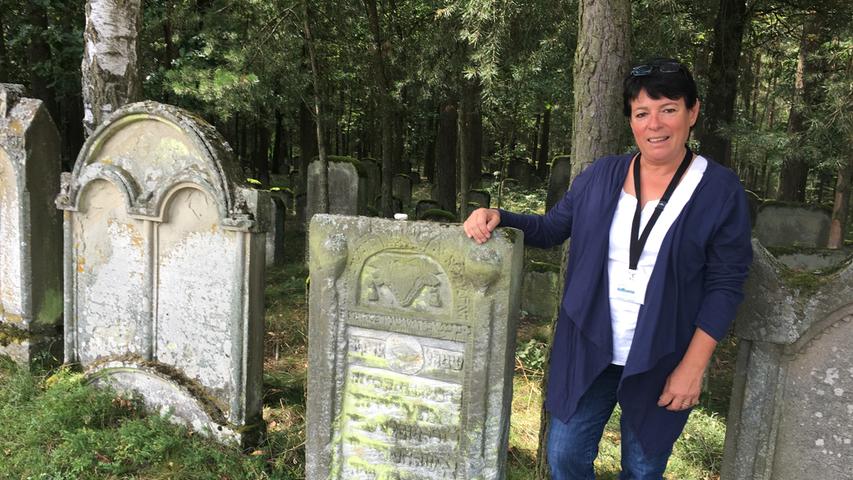 Der jüdische Friedhof Zeckern gehört zu den ältesten und größten in Bayern. Touristenführerin Christiane Kolbet öffnet der Wanderreporterin das schmiedeeiserne Tor, damit sie die rund 800 Grabsteine aus der Nähe betrachten kann.