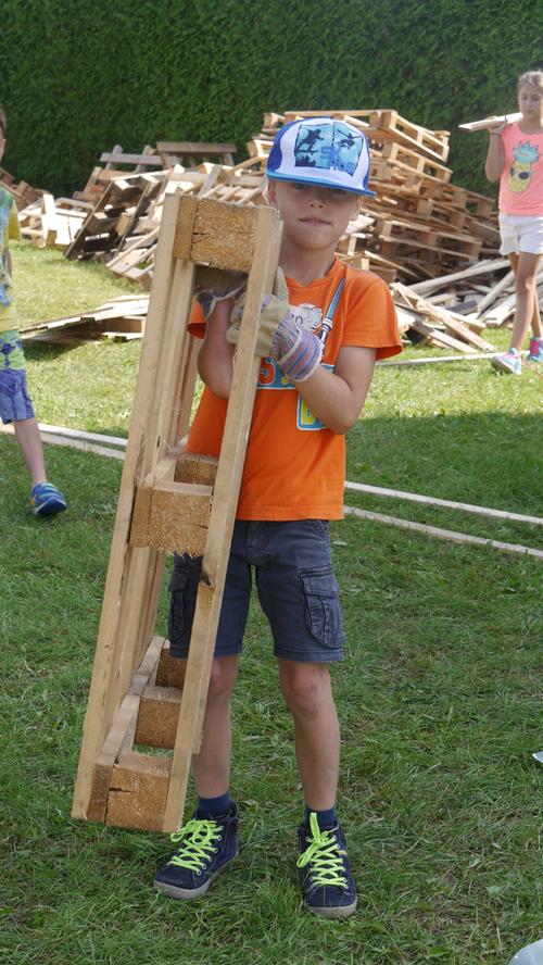 Hier kommt neues Baumaterial: Emilian schleppt eine Holzpalette heran.
