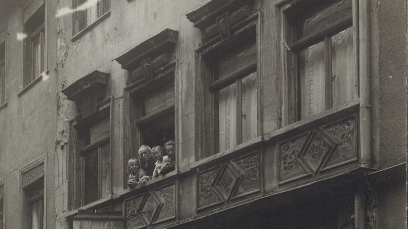 Carl Rößler, seine Frau Lina und die Enkelsöhne Fritz und Artur lächeln dem Fotographen entgegen, der die Schneiderei 1924 auf Zelluloid bannt.