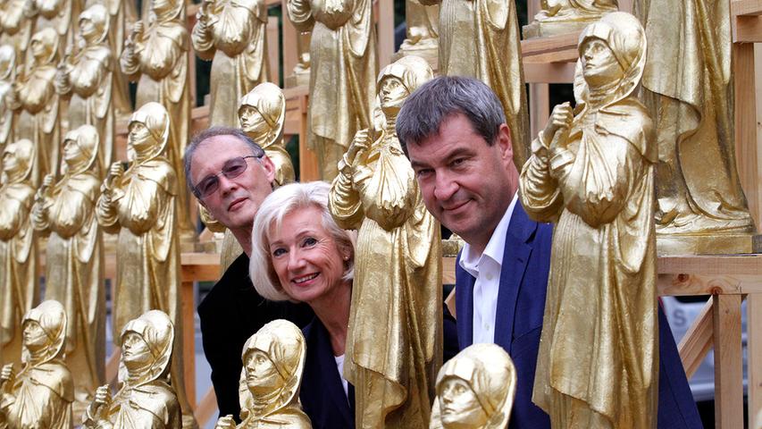 Am Freitag wurde die Installation von Künstler Ottmar Hörl (links), Finanzminister Markus Söder und Kulturreferentin Julia Lehner offiziell eröffnet. Bis zum 17. September stehen die 600 goldfarbenen Kunststoffrepliken der "Nürnberger Madonna" auf dem Kornmarkt vor dem GNM.