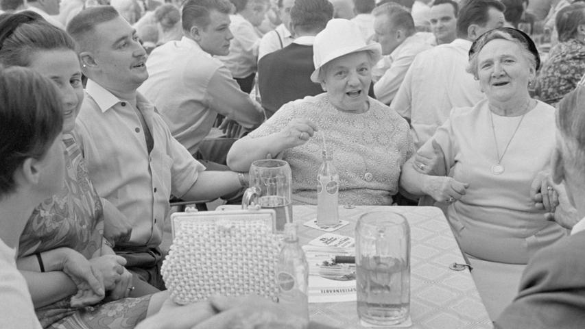 Frohe Zeltbesucher machen kräftig mit: Zur "Musi" schunkeln und singen sie beim großen Volksfest-Frühschoppen.  Hier geht es zum Kalenderblatt vom 6. September 1967: Volksfest-Frühschoppen mit Gaudi