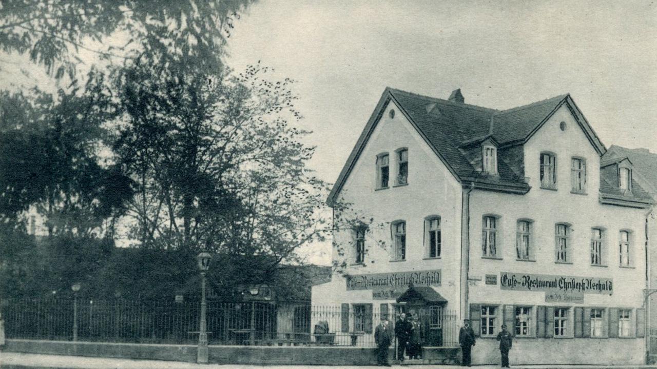 Die Platnersanlage im Jahr 1905: Wirt, Stammgäste und zwei Straßenbahnschaffner stehen beim Fototermin vor dem „Café-Restaurant Christoph Uschald“ stramm.