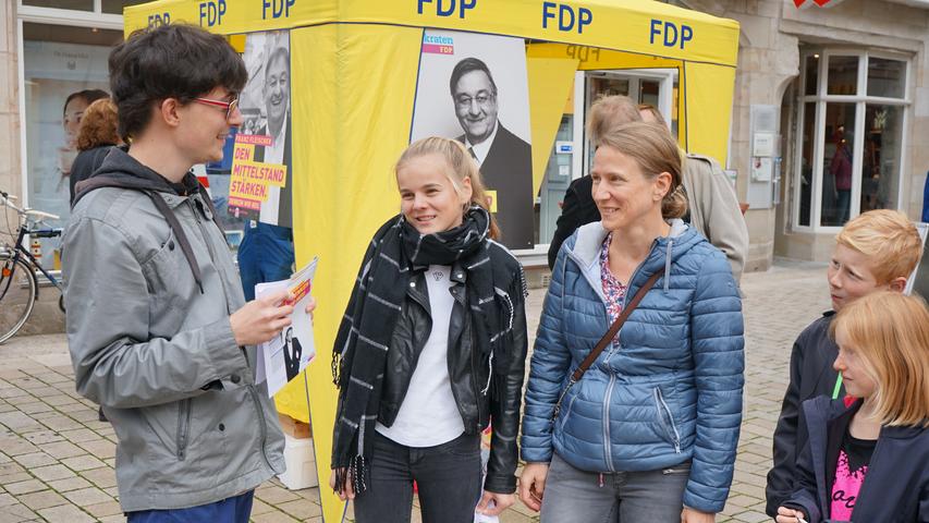 Bitte recht freundlich: ein junger FDP-Helfer im Gespräch.