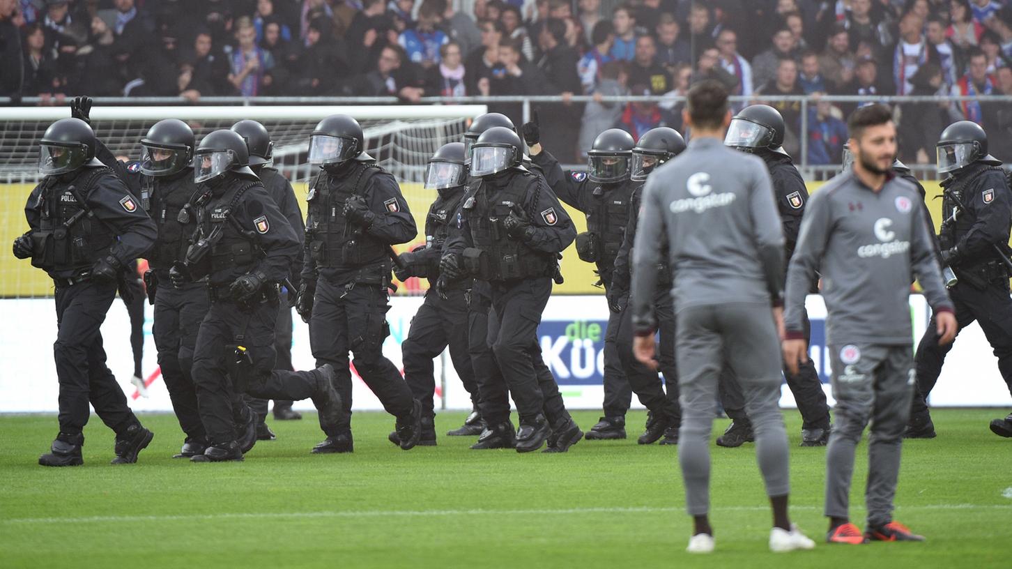 Etwa 25 Chaoten hatten den Platz in Kiel vor Spielbeginn gestürmt. Die Polizei (hier im Bild) musste eingreifen.
