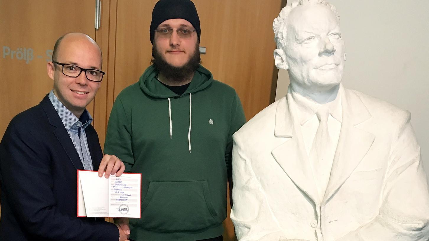 SPD-Chef Thorsten Brehm (l) überreicht dem 23-jährigen Willy Brandt das Parteibuch der SPD. SPD-Chef Thorsten Brehm (l) überreicht dem 23-jährigen Willy Brandt das Parteibuch der SPD.