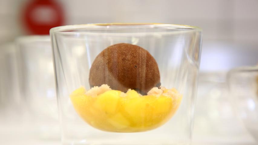 Im Inneren der Pralinenkugel wartet Schokolade, gebettet auf Passionsfruchtragout.