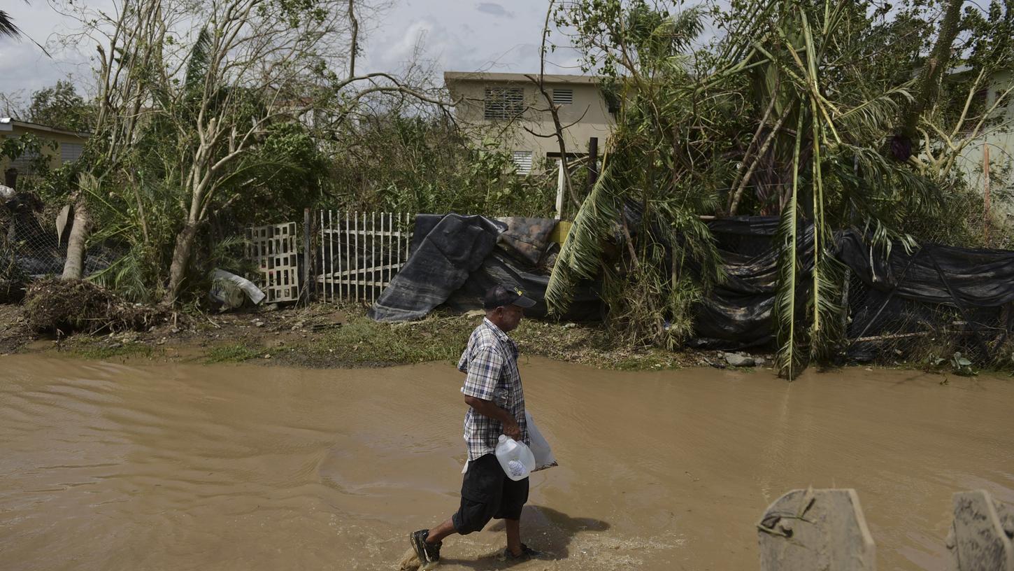 Ein Mann watet am 22. September durch eine überflutete Straße in Toa Baja (Puerto Rico), nachdem der Tropensturm Maria über die Insel hinweggezogen war. Wegen der starken Regenfälle von Hurrikan Maria wurden Bewohner in Sicherheit gebracht, da nach den verheerenden Überschwemmungen der Bruch eines großes Staudamms droht.