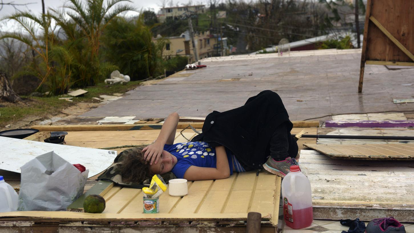 Ein Mädchen liegt am 24. September in Coamo (Puerto Rico) auf den Trümmern ihres zerstörten Hauses.