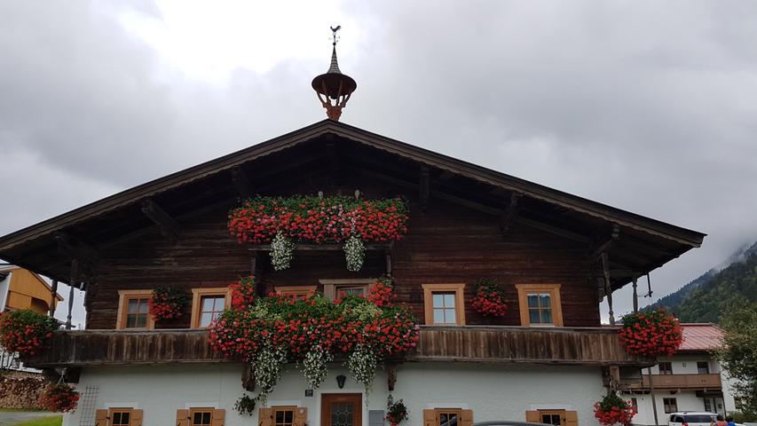 Prachtvolle Häuser, üppiger Blumenschmuck: Bauernhäuser im Pillerseetal sind eine Augenweide.