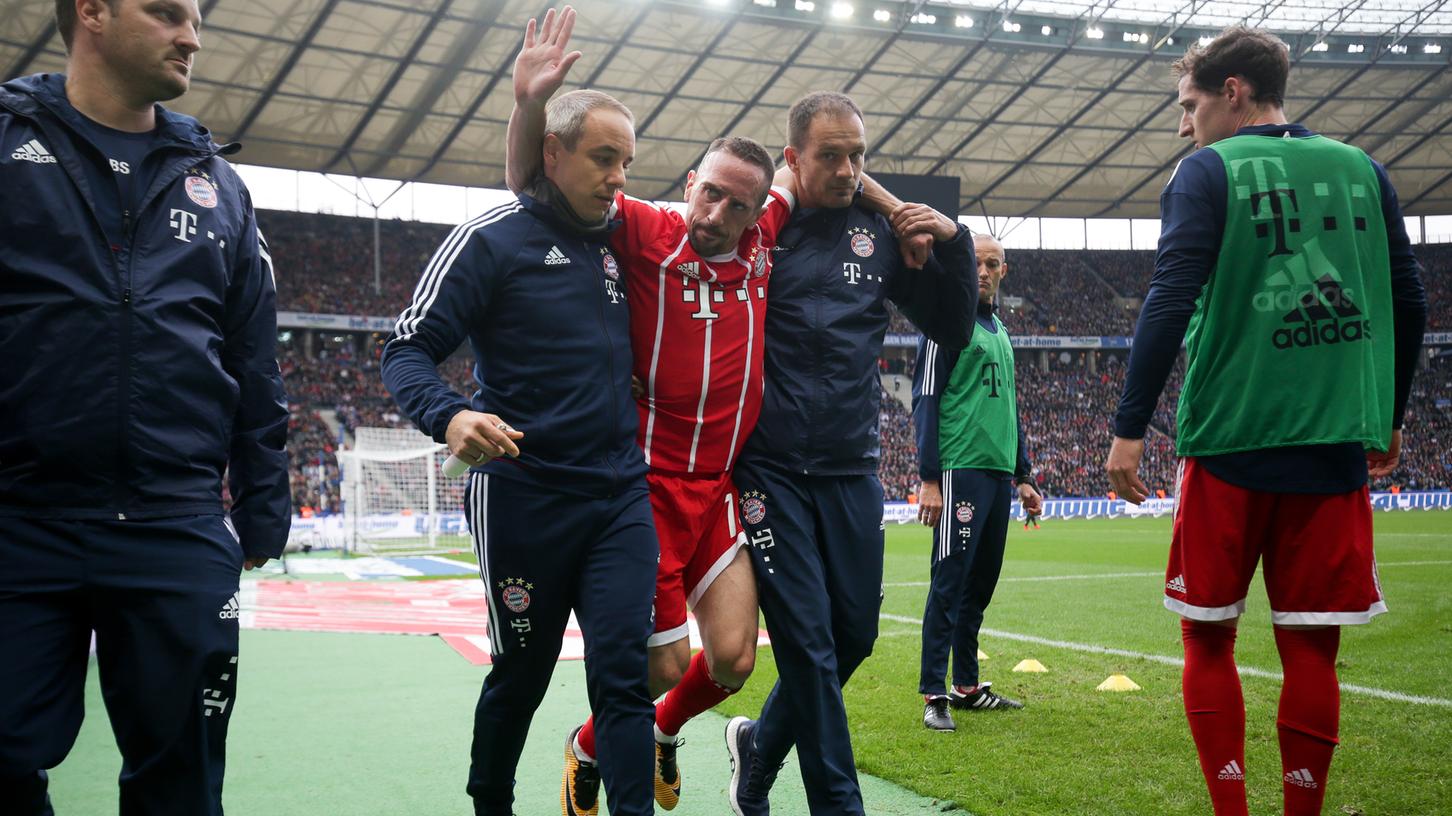 Nach einem Riss des Außenbandes im Knie muss Franck Ribéry vom FC Bayern München beim Verlassen des Platzes gestützt werden.