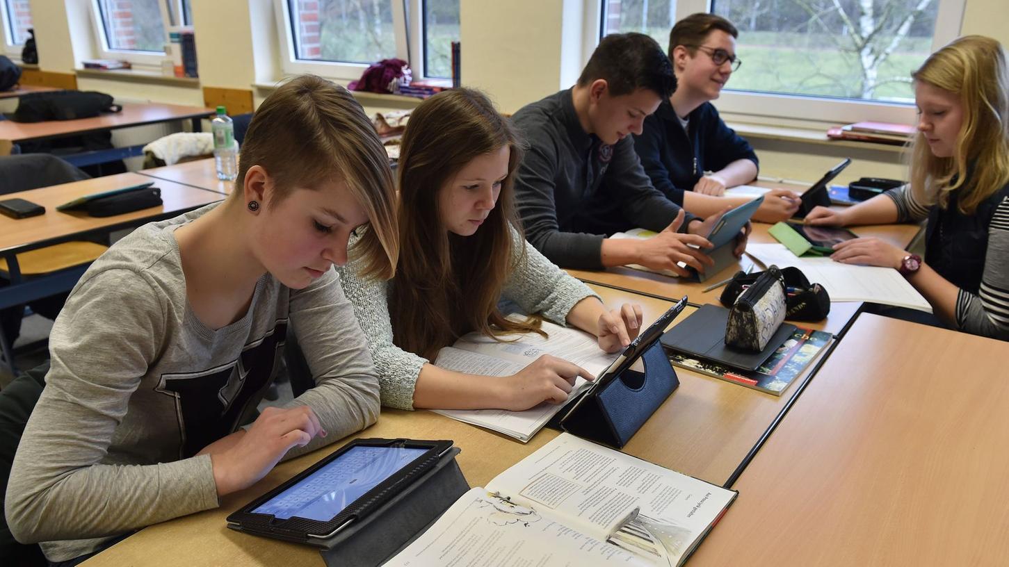 Schüler und Schülerinnen arbeiten in ihrem Klassenzimmer am Tablet: Dieser Anblick dürfte in einigen Jahren zur Gewohnheit geworden sein. Die Regierung möchte nun "Digitale Klassenzimmer" in Bayerns Schulen einführen.