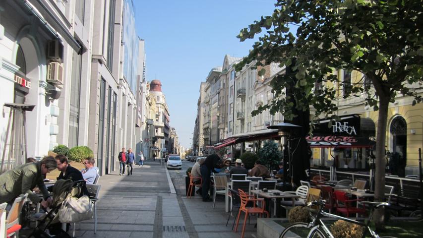 Straßenszene in Belgrad: In der Einkaufsmeile finden sich viele schöne Cafes.Wenige Meter daneben aber stehen marode öffentliche Gebäude.