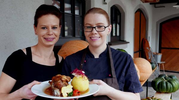 Einst nur eine baufällige Getreidemühle – heute ein feines Gasthaus samt Brauerei: der Gasthof Kohlenmühle in Neustadt an der Aisch. Köchin Katrin Bodendörfer (re.) überreicht Kellnerin Daniela Steiler das reich verzierte Schäufele. Zum Traditionsgericht gibt es im Gasthof Bier aus der hauseigenen Brauerei.