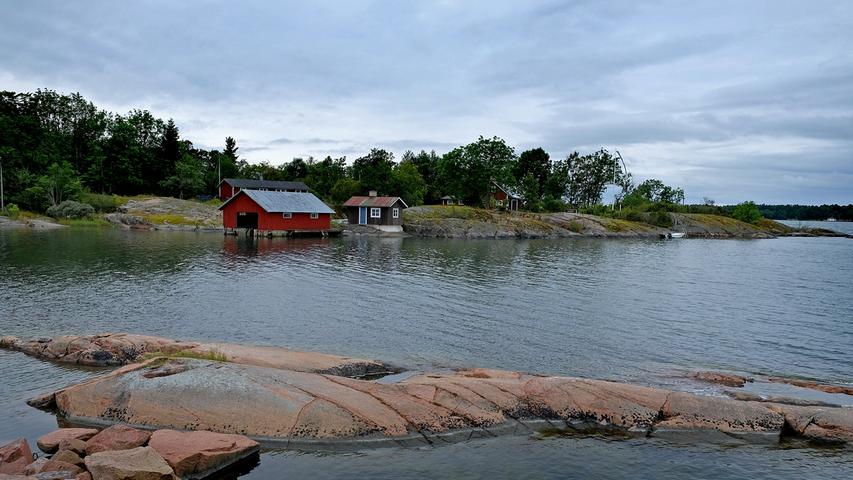 Holzhäuser an einem See auf Åland.