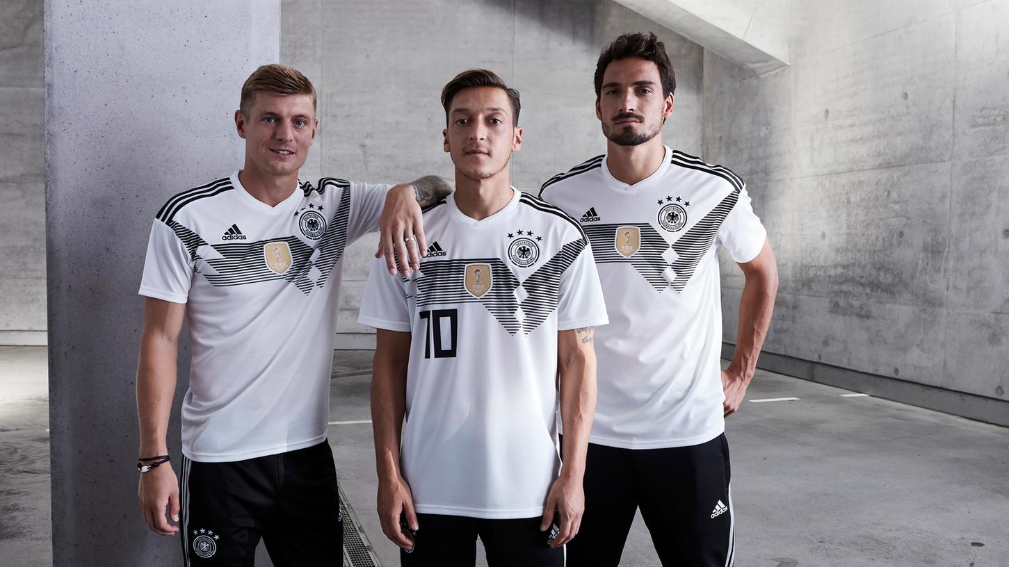 Toni Kroos, Mesut Özil und Mats Hummels präsentieren das neue Trikot der deutschen Fußball-Nationalmannschaft, in dem die Titelverteidigung in Russland im nächsten Jahr gelingen soll.