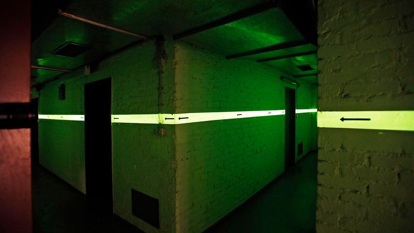 Fluoreszierende Streifen an den Wänden sollten die Orientierung auch im Dunkeln ermöglichen. Der Bunker unter dem Innenhof des DB Museums besteht aus insgesamt 28 Räumen. Dort sollten Bahn-Mitarbeiter den Zugverkehr in großen Teilen Nordbayerns aufrechterhalten.