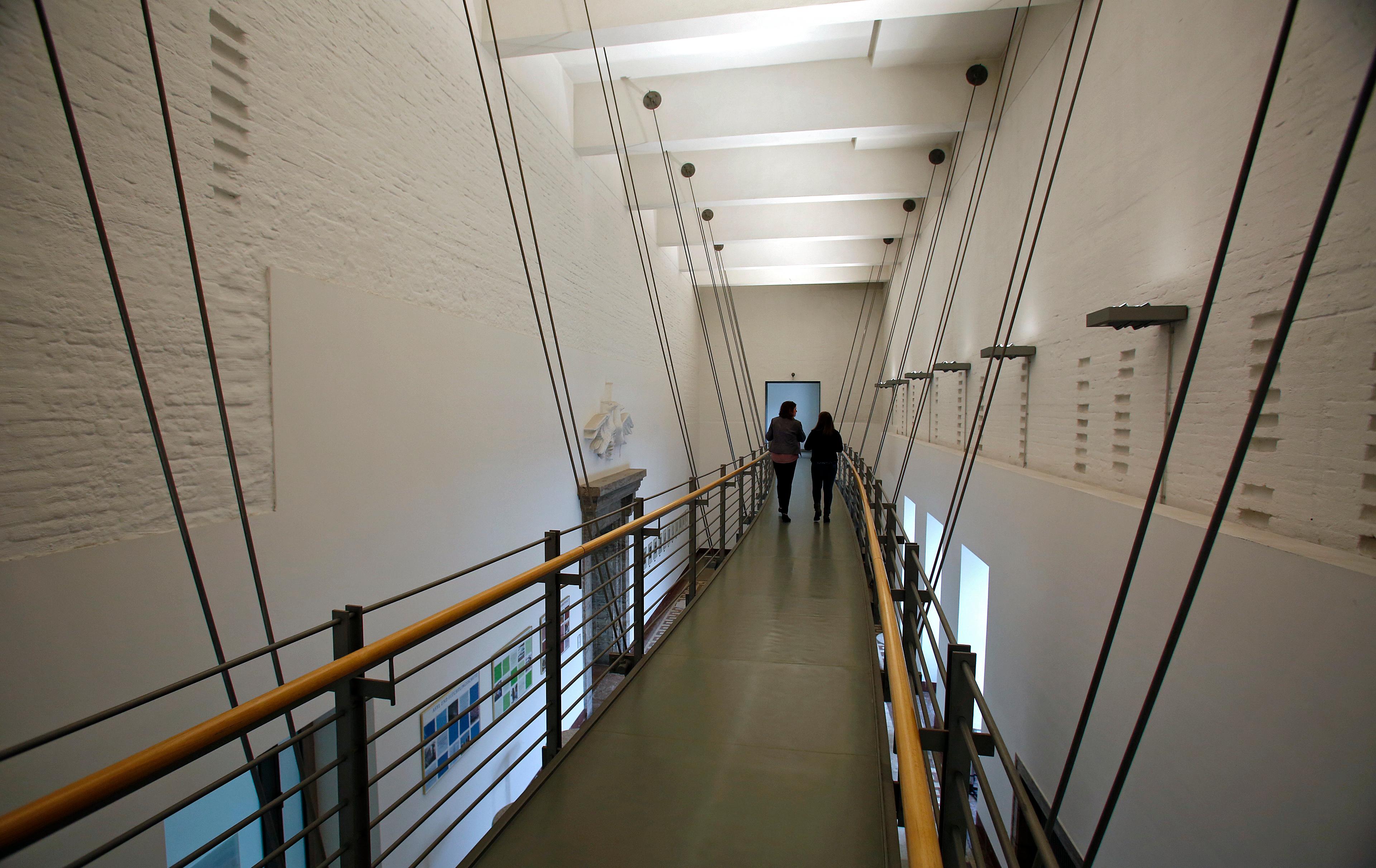 Geschichte trifft auf Moderne. Die Stahlbrücke ermöglicht den Weg in den dritten Stock. Die Wände sind zum Teil bewusst unverputzt geblieben.