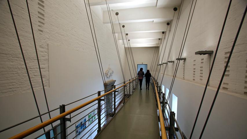 Drinnen trifft heute deswegen Geschichte auf Moderne: Die Stahlbrücke ermöglicht den Weg in den dritten Stock. Die Wände sind zum Teil bewusst unverputzt geblieben. Sie wollen mehr erfahren über die ehemalige SS-Kaserne? Dann klicken Sie hier!